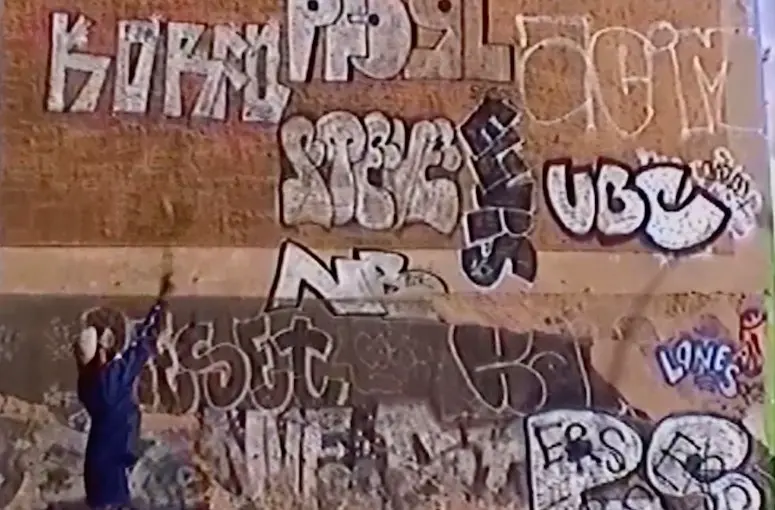eine Hauswand, die mit verschiedenen Graffiti beschmiert ist