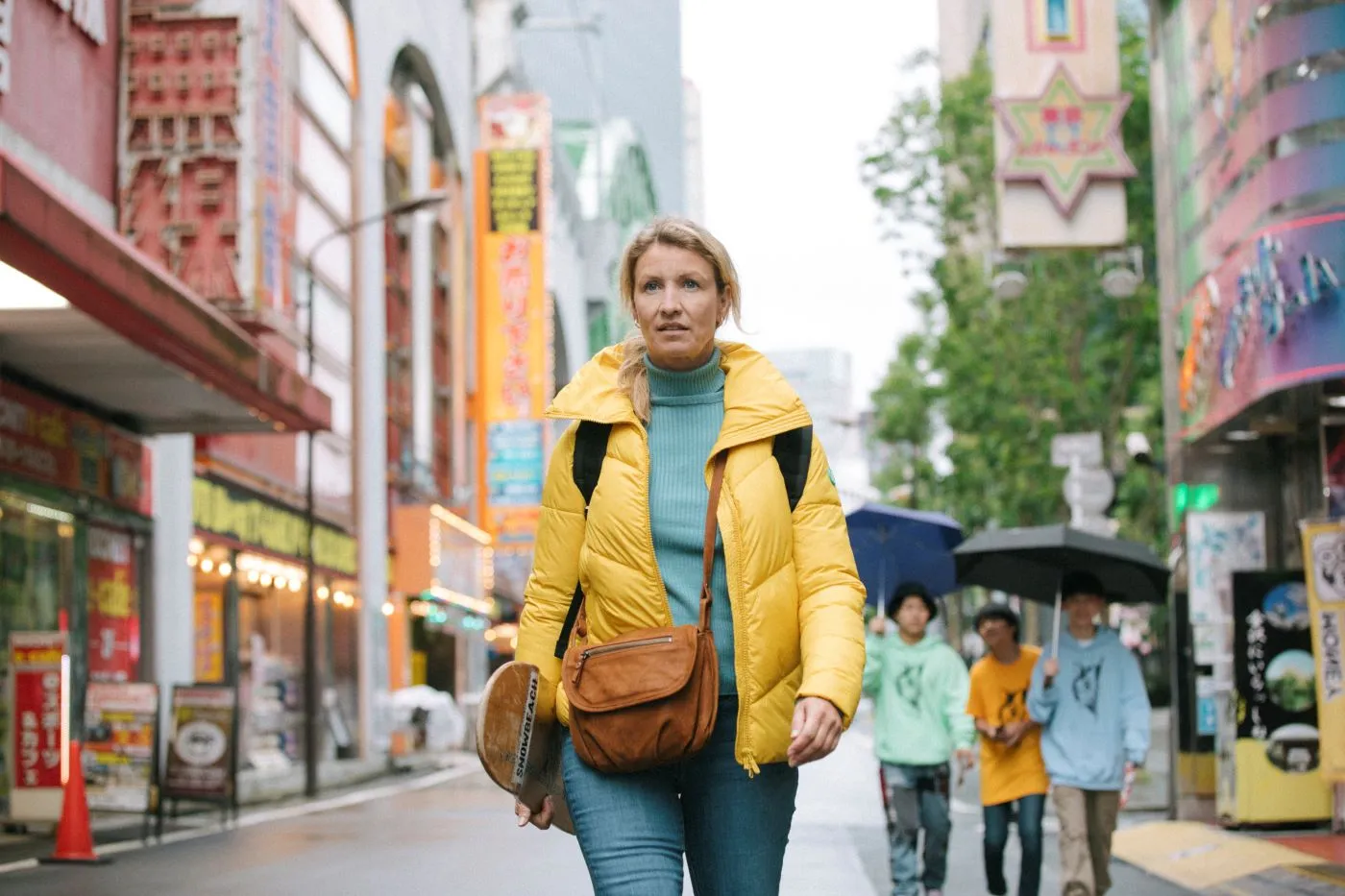 eine Frau im gelben Anorak spaziert durch die Innenstadt