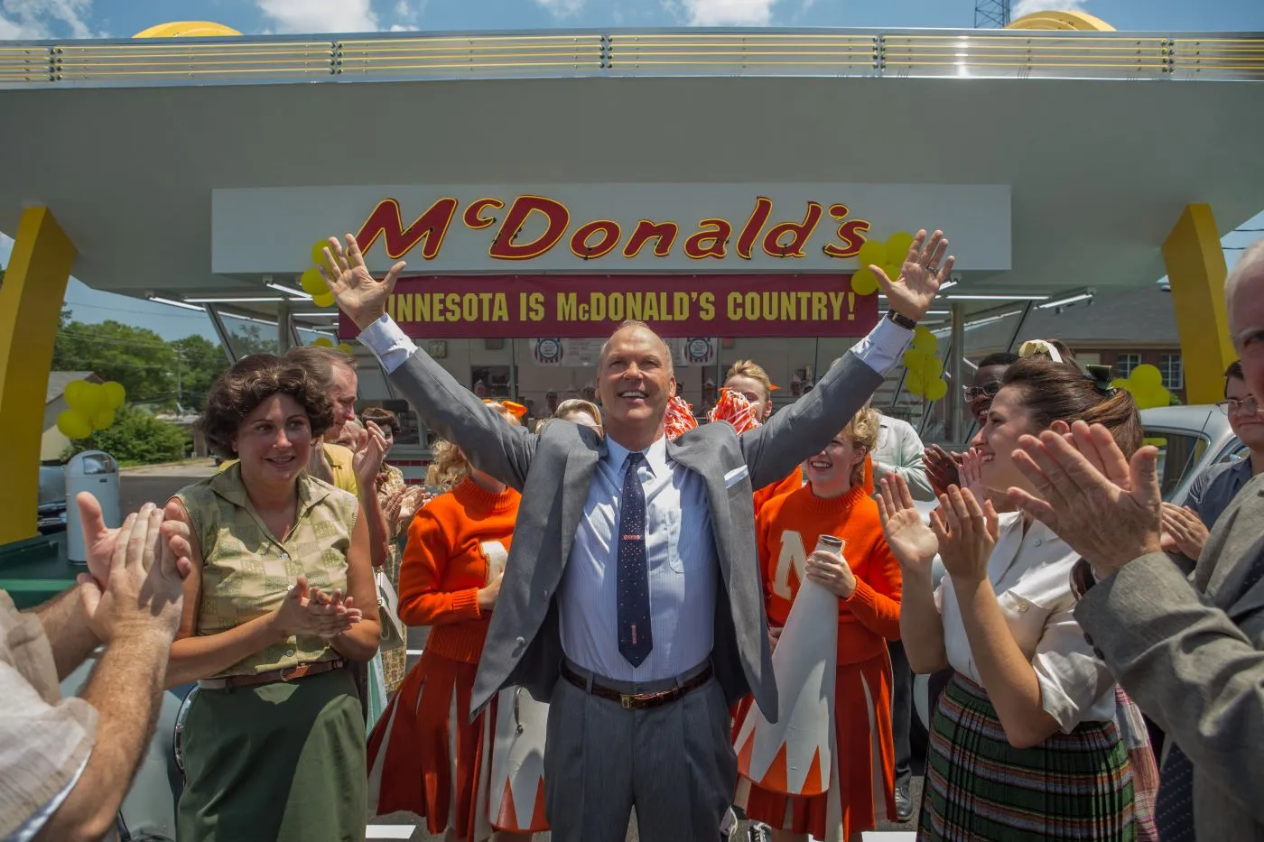 1950er Jahre, vor einem McDonalds-Gebäude hat sich eine Menschentraube versammelt, in der Mitte Ray Kroc (Michael Fassbender) in einem grauen Anzug, der die Arme freudig nach oben reißt