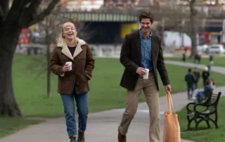 Almut (Florence Pugh) und Tobias (Andrew Garfield) schlendern vergnügt einen Gehweg entlang, sie hält einen Kaffeebecher in der Hand, er einen Einkaufsbeutel