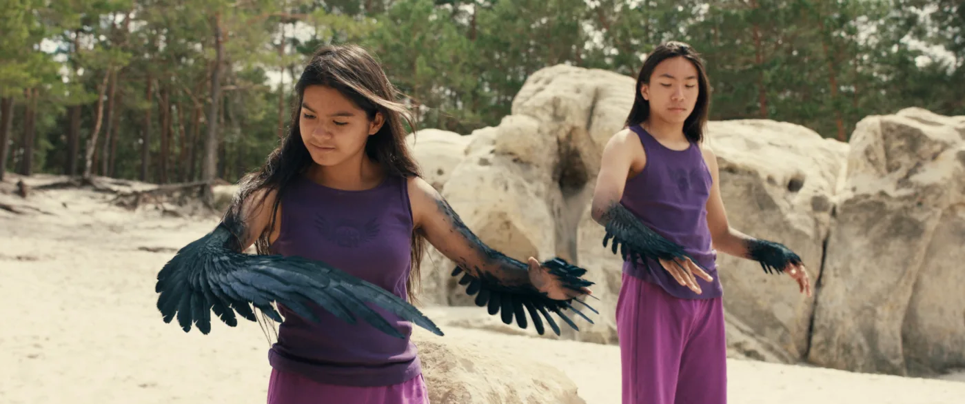 Die Raben-Wandler:innen Shadow (Tamino Beba) und Wing (Samibah Straits) verwandeln sich in ihre Tiergestalt.