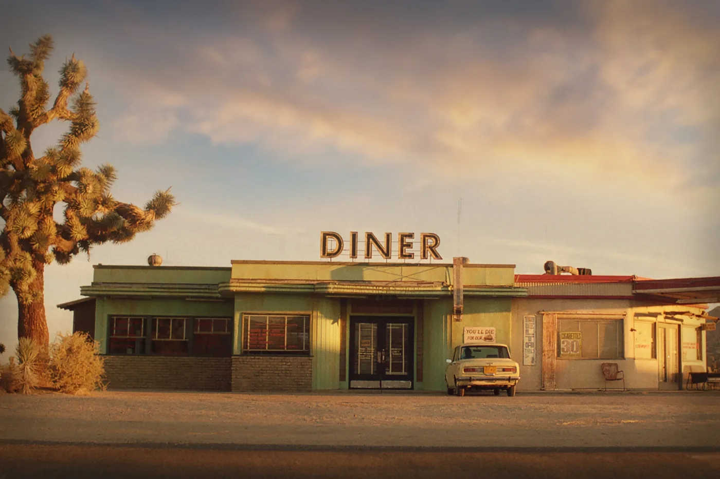 ein Diner in der kahlen Wüstenlandschaft Arizonas, ein einsames Auto parkt davor, links daneben steht ein Baum