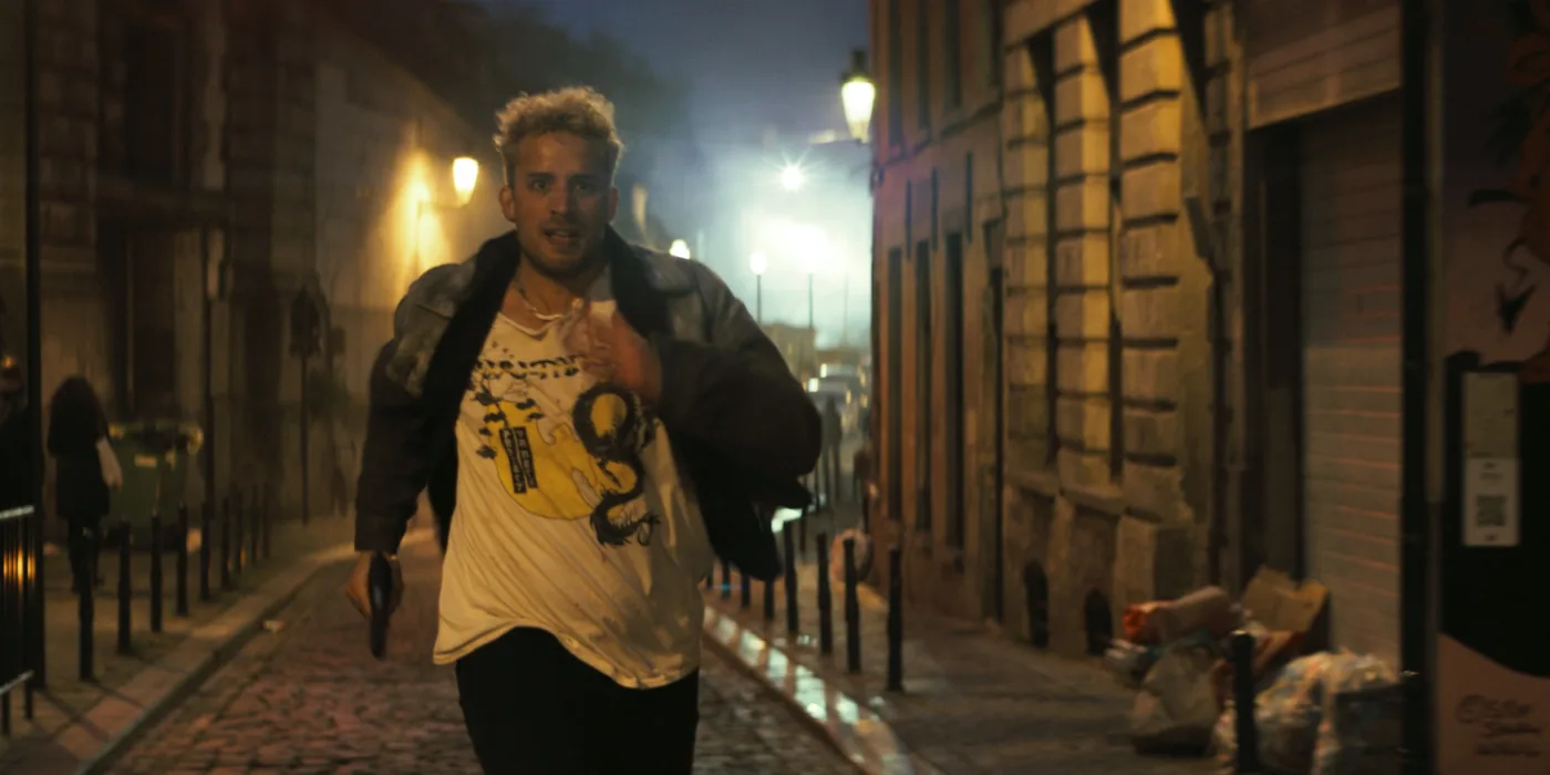 ein blonder Mann rennt des Nachts eine verlassene Straße entlang
