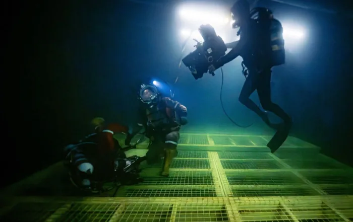 Simu Liu und Crewmitglieder am Set unter Wasser