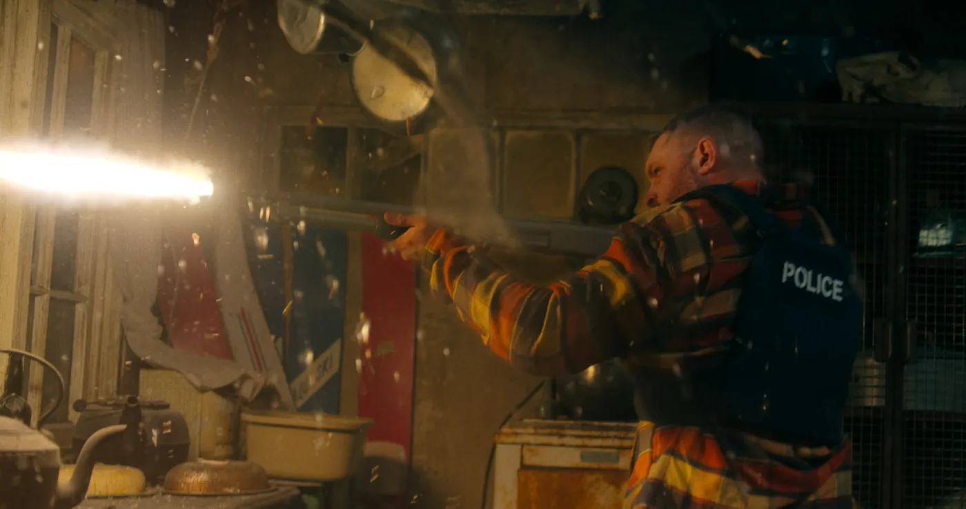 Tom Hardy als Cop schießt mit einem Maschinengewehr