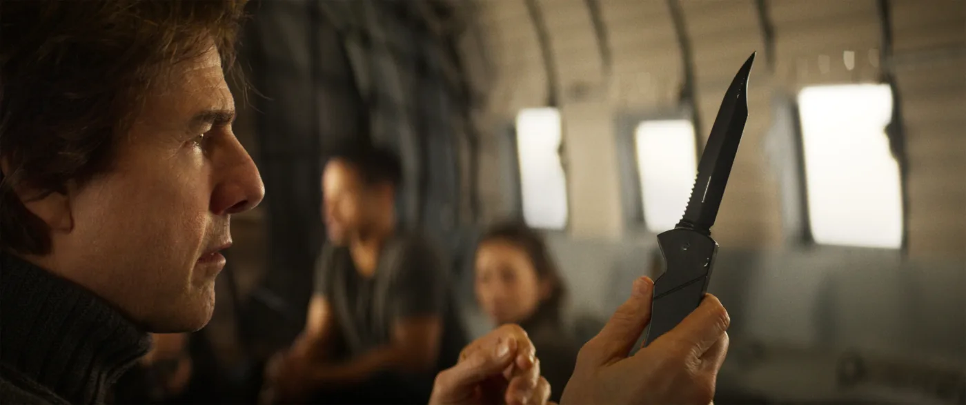 Tom Cruise als Ethan Hunt steht in einem Flugzeug und hält ein Messer hoch
