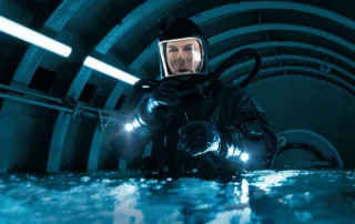 Tom Cruise als Ethan Hunt in einem schwarzen Taucheranzug in einem Gang, der sich mit Wasser füllt