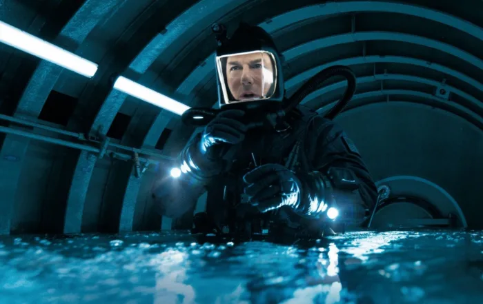 Tom Cruise als Ethan Hunt in einem schwarzen Taucheranzug in einem Gang, der sich mit Wasser füllt