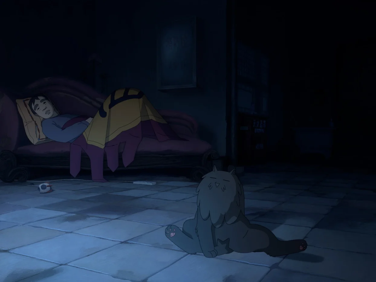 In einem verdunkelten Zimmer liegt eine Person auf einem Sofa, ist mit einer Decke zugedeckt. Vor dem Sofa sitzt eine graue Katze. Die Szenerie wird vom kühlen Licht des Fernsehers erhellt, der außerhalb des Bildes steht.