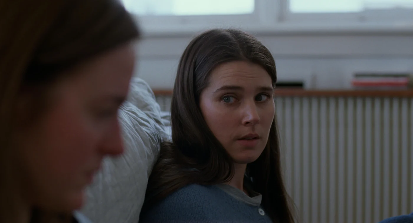 Szenenbild aus Sentimental Value: Zwei Frauen sitzen nebeneinander in einem Zimmer auf dem Boden vor einer Heizung.